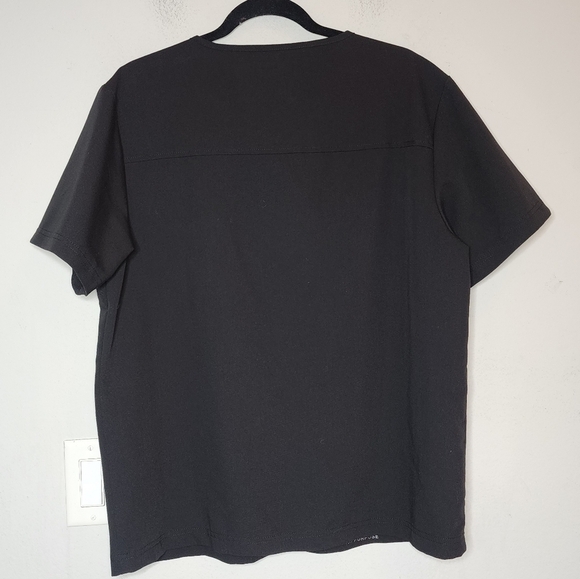 Jaanuu black scrub top. 1 zip chest pocket.  Short sleeve v-neck. Women's size L - Picture 10 of 14